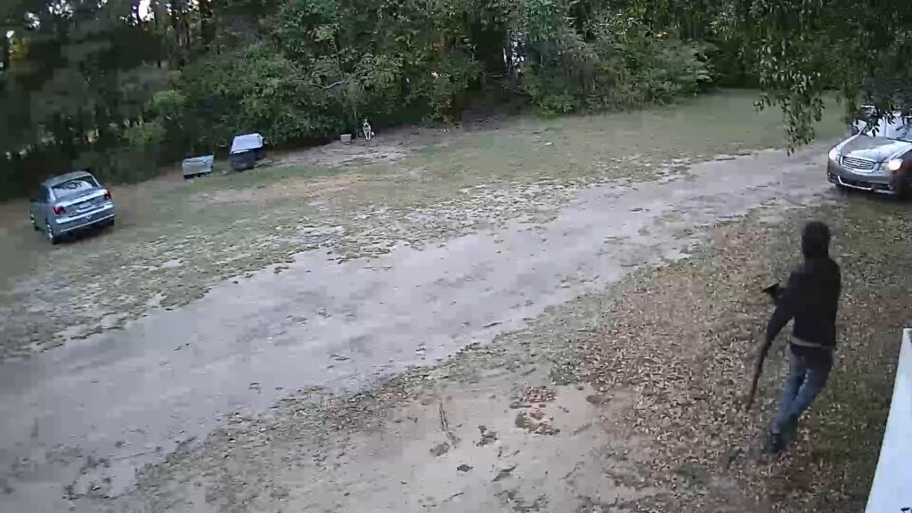 A screen capture from a surveillance video shows Jonas Washington fleeing from a house he has just robbed carrying a long gun he stole from the residence.