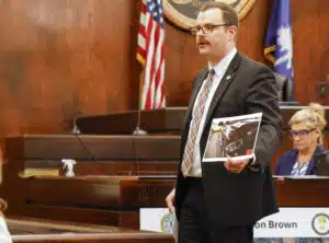 Assistant Solicitor Jared Shedd shows the jury a photo of damage to the headlight of a vehicle driven by defendant Clinton Brown sustained in a hit-and-run collision that killed pedestrian Rediedre Holmes in 2019.
