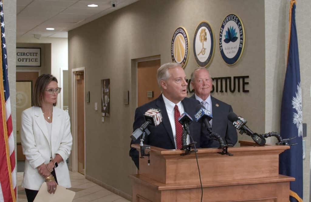 Solicitor Stone (center) and Sheriff P.J. Tanner (right) discuss charges against defendants in a July 4, 2026, shooting at Hilton Head Island's Coligny Beach. Deputy Solicitor Mary Jones looks on.